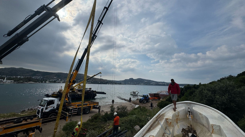 Bodrum'da kıyıya terkedilmiş sahipsiz tekneler vinçlerle kaldırıldı